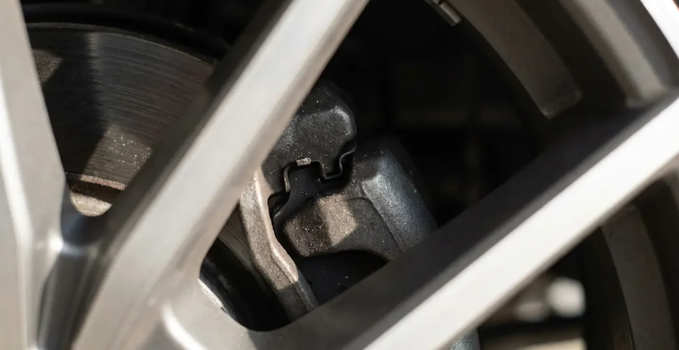 Gros plan sur une roue de voiture avec jantes ajourées permettant de voir les plaquettes de frein et le disque