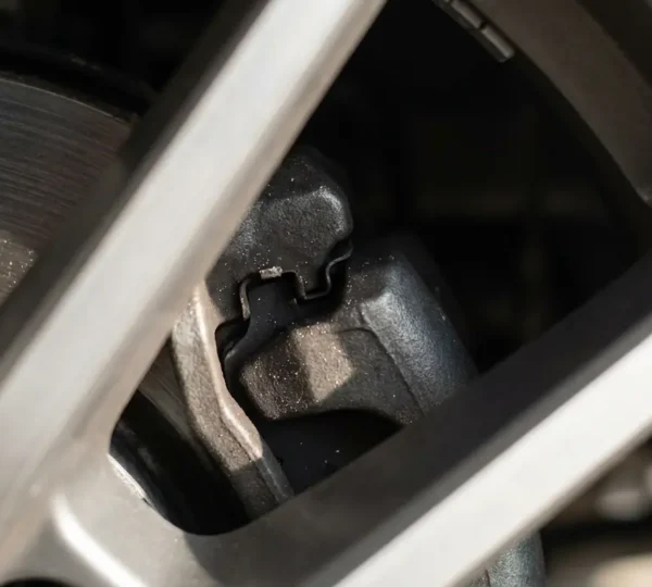 Gros plan sur une roue de voiture avec jantes ajourées permettant de voir les plaquettes de frein et le disque