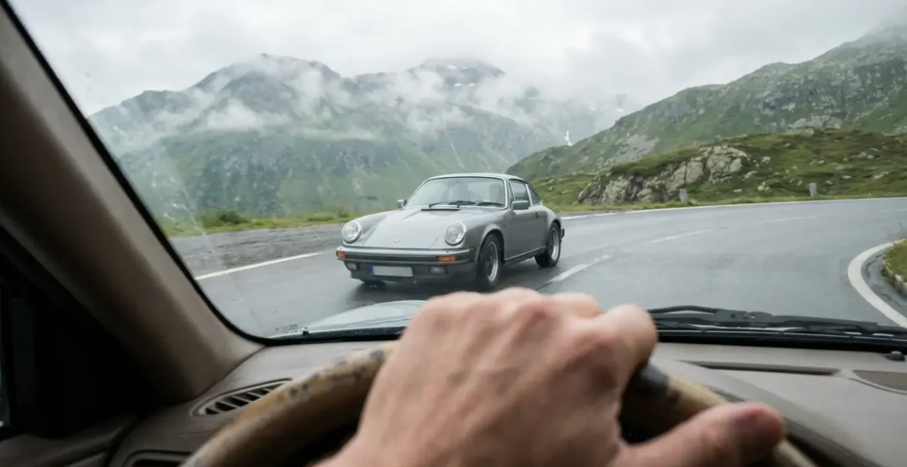 Porsche 911 grise en mouvement sur route de montagne sinueuse