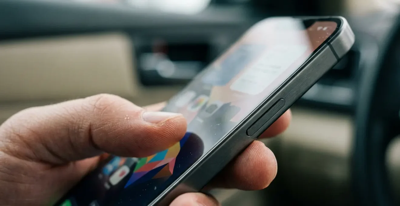 Mains tenant un smartphone montrant une interface d'application sans texte lisible